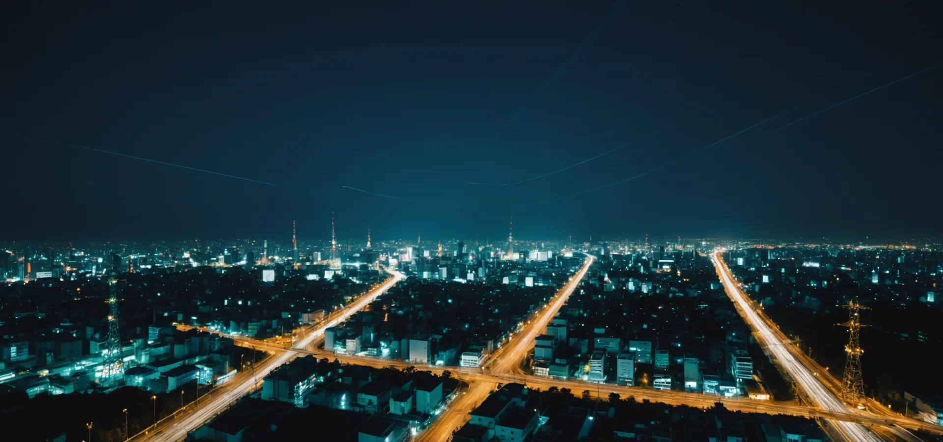 Aerial view of high-voltage transmission grid at night in western Japan with teal-lit control infrastructure